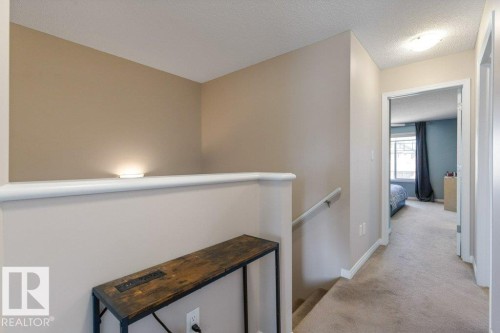 Hallway featuring light beige walls, a white handrail, and carpeted flooring - 3119 Carpenter Landing Landing, Edmonton, AB - Indoor Photo Showing Other Room