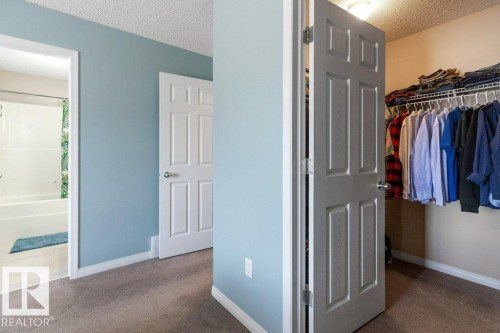 This property features a room with light blue painted walls, carpeted flooring, and a white six-panel door - 3119 Carpenter Landing Landing, Edmonton, AB - Indoor