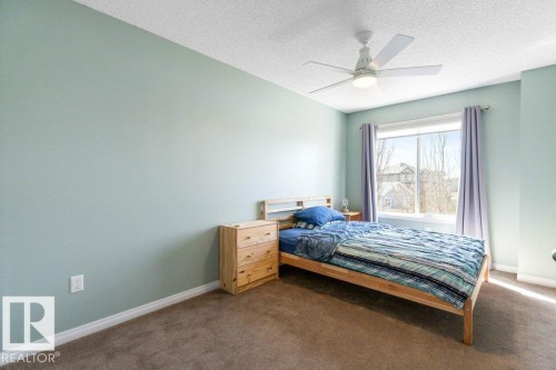 The property features a room with light green walls, a window with curtains, and a ceiling fan - 3119 Carpenter Landing Landing, Edmonton, AB - Indoor Photo Showing Bedroom