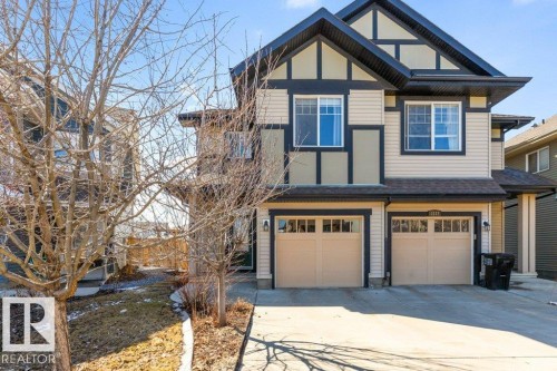 The property features a two-story exterior with light-colored siding and dark trim accents - 3119 Carpenter Landing Landing, Edmonton, AB - Outdoor With Facade