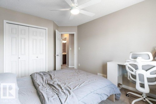 This room features light-colored walls and carpeted flooring, a ceiling fan with integrated lighting, and a closet with bi-fold doors - 3119 Carpenter Landing Landing, Edmonton, AB - Indoor Photo Showing Bedroom