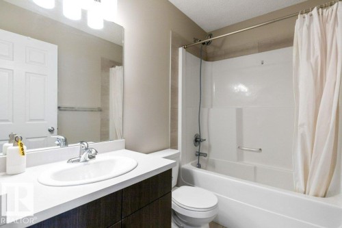 Bathroom featuring a vanity with a white countertop, an undermount sink, and chrome fixtures - 3119 Carpenter Landing Landing, Edmonton, AB - Indoor Photo Showing Bathroom