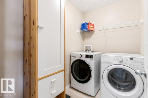 The property features a dedicated laundry area with a wire shelf, a washer, and a dryer - 3119 Carpenter Landing Landing, Edmonton, AB - Indoor Photo Showing Laundry Room