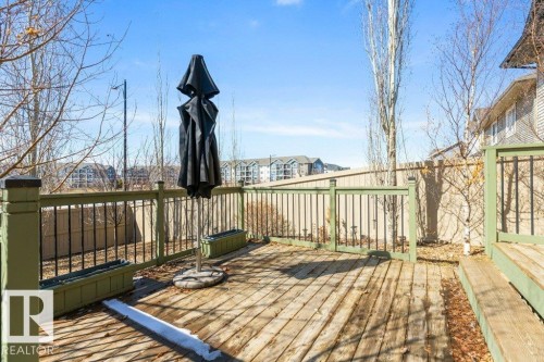 The property features a spacious wooden deck with green railings and black balusters - 3119 Carpenter Landing Landing, Edmonton, AB - Outdoor With Deck Patio Veranda