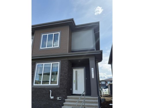 The property features contemporary architecture with a combination of dark siding and stone cladding on the exterior - 6371 King Wynd, Edmonton, AB - Outdoor