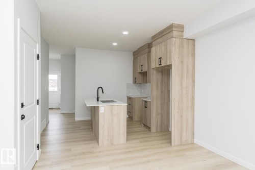 The property features an open-concept living space with light wood-style flooring and recessed lighting - 6371 King Wynd, Edmonton, AB - Indoor