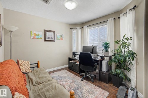 This versatile room features hardwood flooring, a window with blinds, and recessed lighting - 21 1850 Mill Woods Road E, Edmonton, AB - Indoor Photo Showing Office