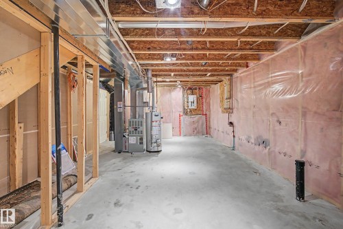 The unfinished basement provides a raw canvas, featuring exposed wooden ceiling joists, a concrete floor, and insulation along the walls, offering potential for customization - 21 1850 Mill Woods Road E, Edmonton, AB - Indoor Photo Showing Basement