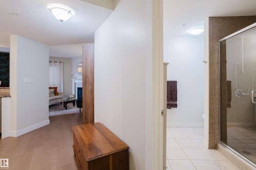 The property features hardwood floors, a bright interior with light-colored walls, and a recessed ceiling light fixture - 206 10108 125 Street, Edmonton, AB - Indoor Photo Showing Other Room