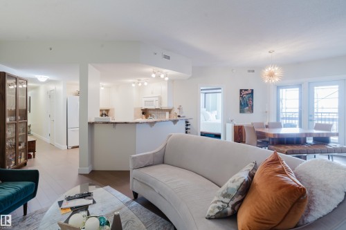 Open concept living area featuring light-colored walls, recessed lighting, and a modern light fixture - 206 10108 125 Street, Edmonton, AB - Indoor Photo Showing Living Room