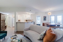 Open concept living area featuring light-colored walls, recessed lighting, and a modern light fixture - 