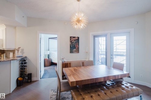 This inviting dining area features dark wood flooring and a contemporary light fixture - 206 10108 125 Street, Edmonton, AB - Indoor Photo Showing Dining Room