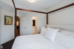 This bedroom features light-colored walls and dark flooring - 