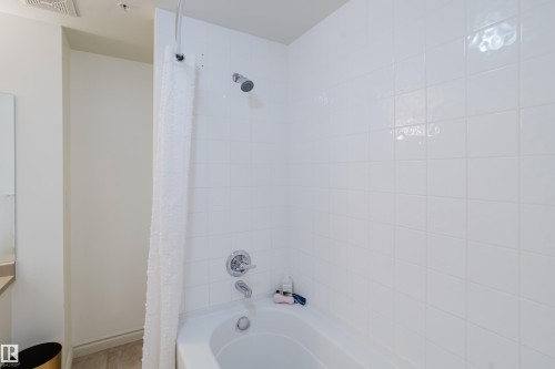 Bathroom features a bathtub with a shower head, subway tile surround, and chrome fixtures - 206 10108 125 Street, Edmonton, AB - Indoor Photo Showing Bathroom