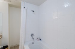 Bathroom features a bathtub with a shower head, subway tile surround, and chrome fixtures - 