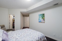 This room features a neutral color palette, a textured ceiling, and a doorway leading to a walk-in closet - 