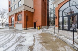 The property features a brick exterior with arched windows, a large glass entrance, and a garage door - 