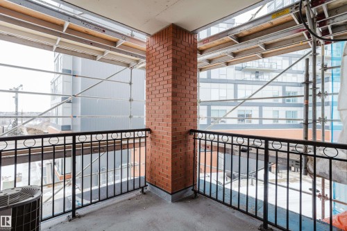 The property includes a private balcony with a brick wall and a black metal railing - 206 10108 125 Street, Edmonton, AB - Indoor Photo Showing Other Room