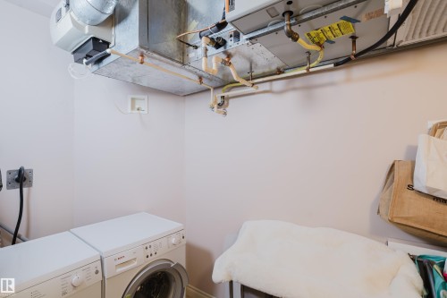 The utility area includes white wall paint, a white washer, and a white dryer - 206 10108 125 Street, Edmonton, AB - Indoor Photo Showing Laundry Room