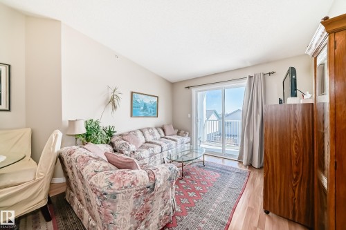 The living area features light-colored walls, a vaulted ceiling, and wood flooring - 324 9525 162 Avenue Nw, Edmonton, AB - Indoor Photo Showing Living Room