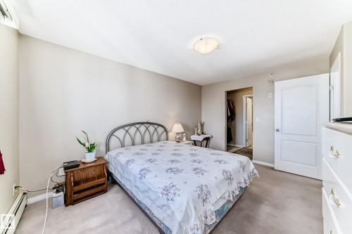 This inviting bedroom features light-colored walls, carpeted flooring, and a ceiling light fixture - 324 9525 162 Avenue Nw, Edmonton, AB - Indoor Photo Showing Bedroom