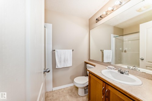 Bathroom featuring a vanity with a white sink, chrome faucet, and wood cabinetry - 324 9525 162 Avenue Nw, Edmonton, AB - Indoor Photo Showing Bathroom