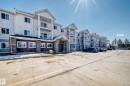 The property features an exterior with white siding and stone accents, along with several balconies - 324 9525 162 Avenue Nw, Edmonton, AB  - Outdoor With Facade 