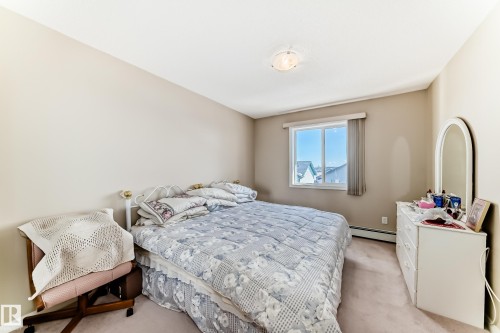 The property features a bedroom with light-colored walls, a window providing natural light, and plush carpeting - 324 9525 162 Avenue Nw, Edmonton, AB - Indoor Photo Showing Bedroom