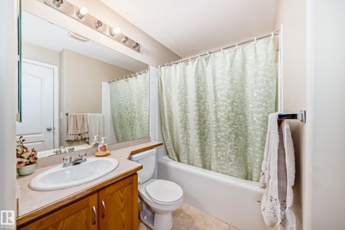 Bathroom featuring a vanity with a light wood cabinet, a white sink, and a large mirror - 324 9525 162 Avenue Nw, Edmonton, AB - Indoor Photo Showing Bathroom