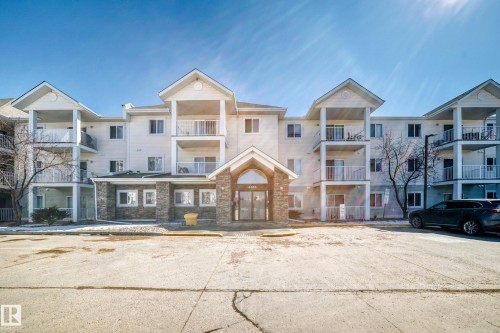 The property features a multi-story exterior with balconies and a stone facade entrance - 324 9525 162 Avenue Nw, Edmonton, AB - Outdoor With Facade
