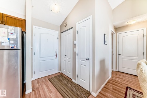 The property entrance features light wood-style flooring, white panel doors, and a ceiling light fixture - 324 9525 162 Avenue Nw, Edmonton, AB - Indoor Photo Showing Other Room