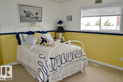 This room features a window with blinds, carpeted flooring, and walls with a two-tone paint scheme - 16832 79 Street Nw, Edmonton, AB - Indoor Photo Showing Bedroom