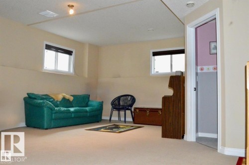 This room features two windows providing natural light, light-colored walls, and a carpeted floor - 16832 79 Street Nw, Edmonton, AB - Indoor