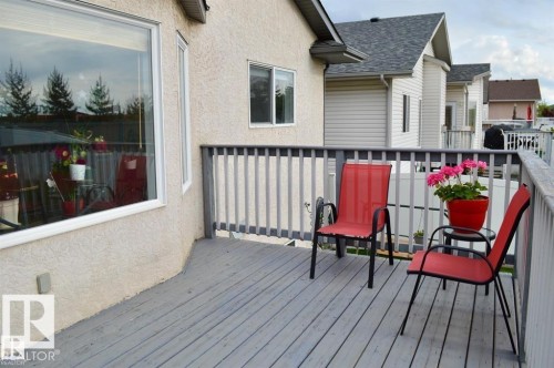 The property features an outdoor deck with a gray painted wood surface and railing - 16832 79 Street Nw, Edmonton, AB - Outdoor With Deck Patio Veranda With Exterior