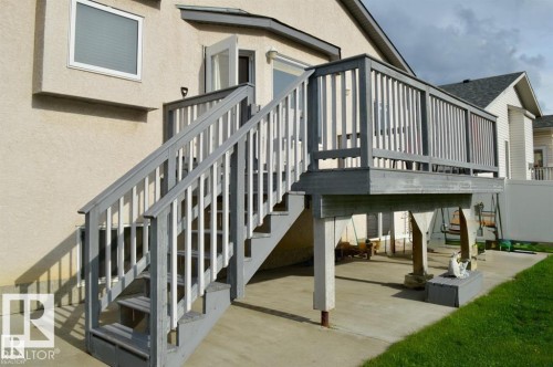 The property features a raised deck with stairs, a concrete patio area, and a patch of grass - 16832 79 Street Nw, Edmonton, AB - 