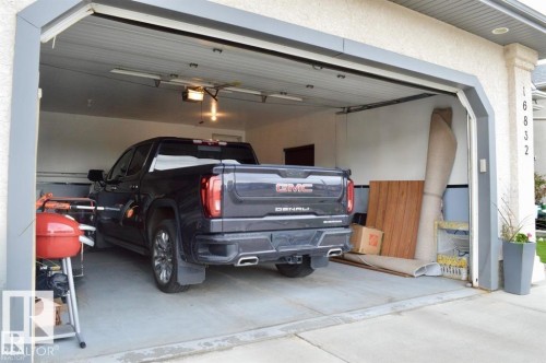 The property features an attached garage with a concrete floor and an overhead door - 16832 79 Street Nw, Edmonton, AB - Indoor Photo Showing Garage
