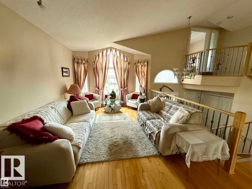 This spacious living area features hardwood floors and a large bay window, providing natural light - 16832 79 Street Nw, Edmonton, AB - Indoor Photo Showing Living Room