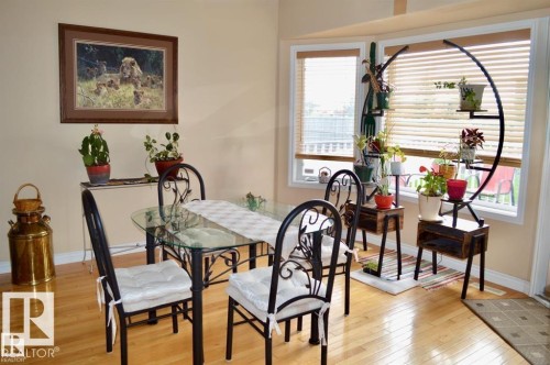 This dining area features hardwood flooring and a bay window with blinds - 16832 79 Street Nw, Edmonton, AB - Indoor Photo Showing Dining Room