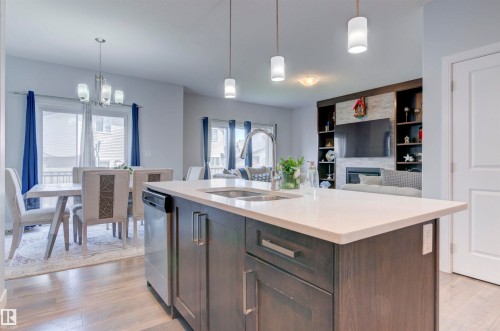 The kitchen features a center island with a sink, stainless steel appliances, and pendant lighting - 8452 Cushing Crest, Edmonton, AB - Indoor Photo Showing Kitchen With Double Sink With Upgraded Kitchen