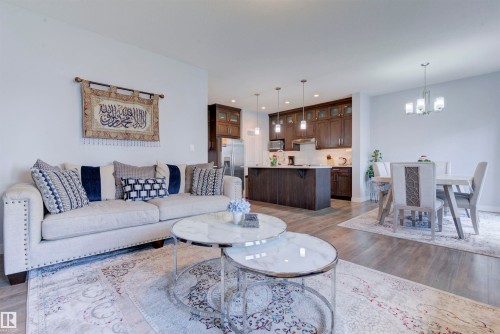 The living area features light-colored walls, wood flooring, and an open layout - 8452 Cushing Crest, Edmonton, AB - Indoor Photo Showing Living Room