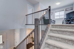 The property features carpeted stairs with a dark wood and metal railing - 