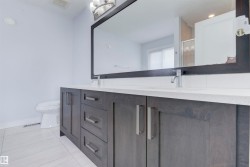 Bathroom featuring a dual vanity with a white countertop, two sinks, and chrome faucets - 