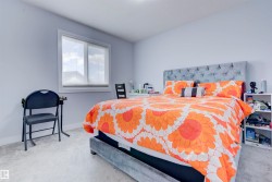 This bedroom features light grey walls and light grey carpet - 