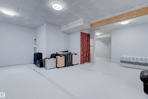 This spacious room features light-colored walls and flooring, with overhead lighting fixtures - 8452 Cushing Crest, Edmonton, AB - Indoor