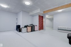This spacious room features light-colored walls and flooring, with overhead lighting fixtures - 