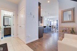 This entry area features light-colored tile flooring, a white interior door, and light-colored walls - 