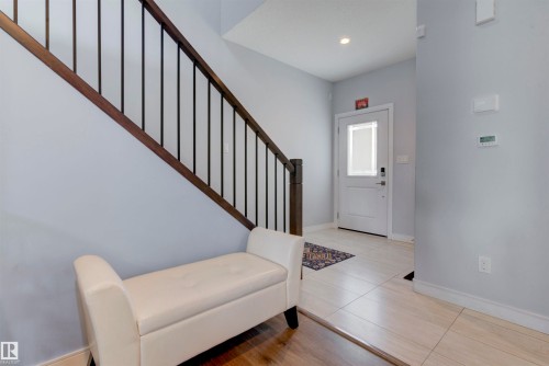 The property features a staircase with dark wood railings and black vertical spindles - 8452 Cushing Crest, Edmonton, AB - Indoor Photo Showing Other Room