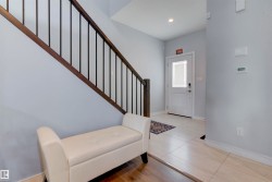 The property features a staircase with dark wood railings and black vertical spindles - 