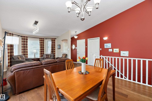The property features a dining area with a hardwood table and chairs, complemented by hardwood flooring - 14 920 119 Street, Edmonton, AB - Indoor Photo Showing Dining Room