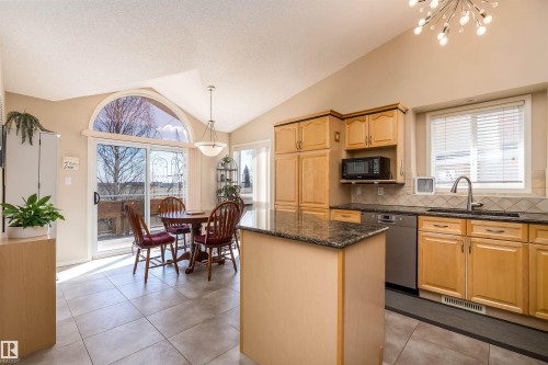 This kitchen features light-toned cabinetry, granite countertops, and stainless steel appliances - 14 920 119 Street, Edmonton, AB - Indoor